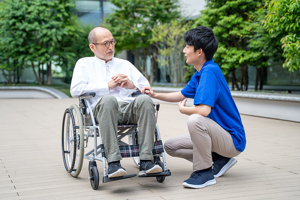 車いすの男性と福祉職員の男性