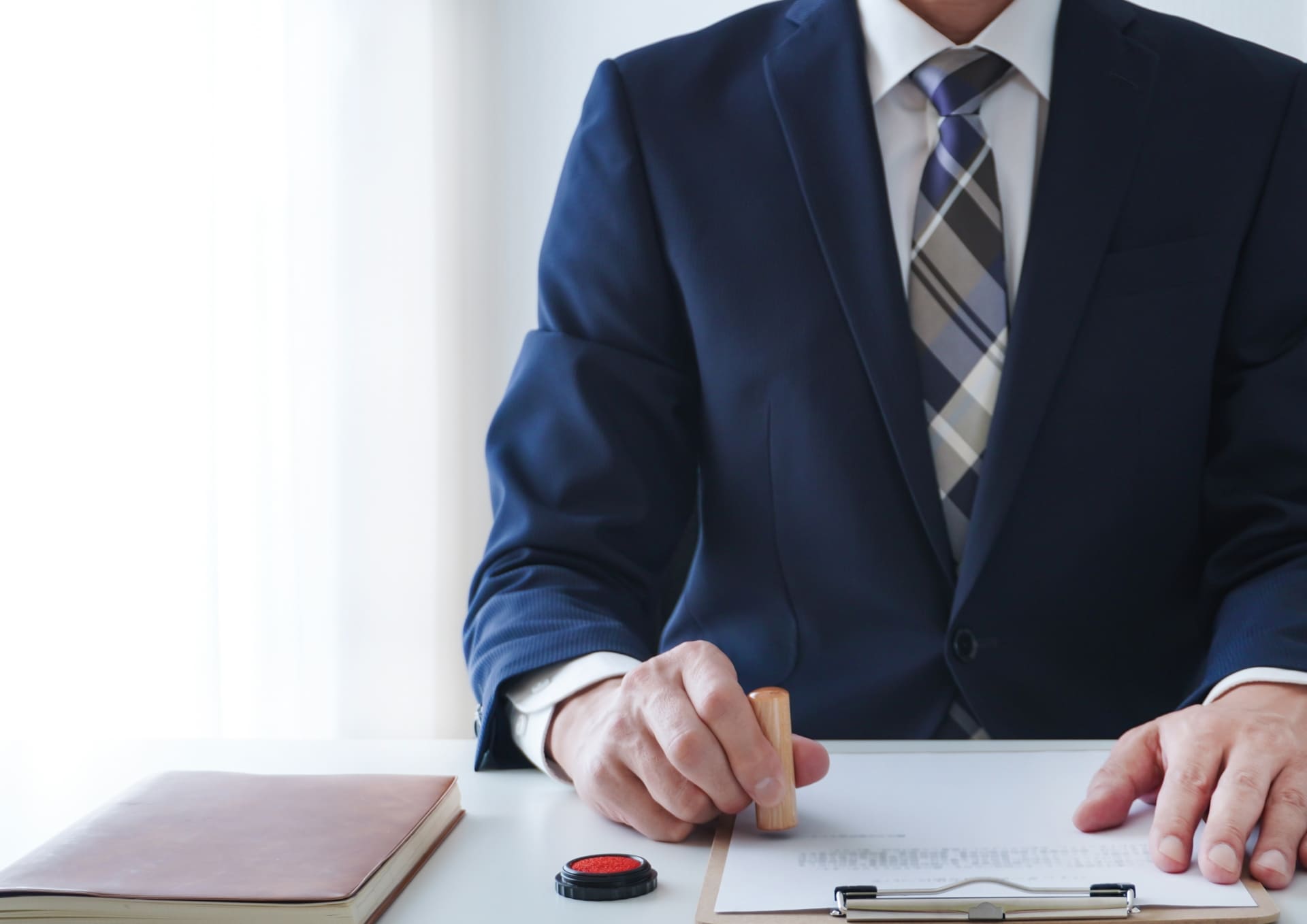 判を押すスーツ姿の男性