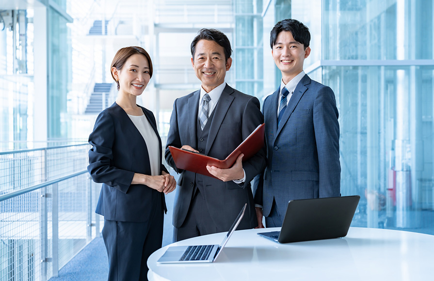 笑顔を向けるスーツ姿の男女