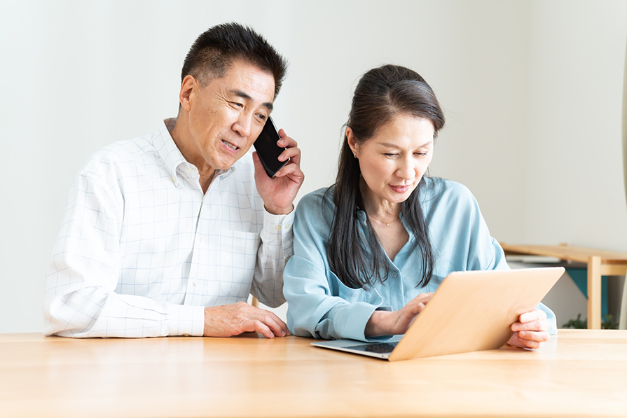 パソコンやスマートフォンで申し込みをする男女