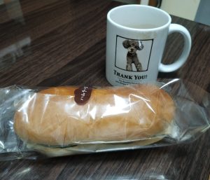 柏市のコッペパン専門店「コッペ田島」ハムチーズパンと、亡くなった愛犬のトイプードルの写真が入ったマグカップの写真です。