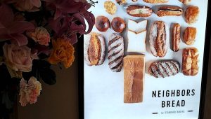 流山おおたかの森SCに新規オープンしたパン屋さん「NEIGHBORS BREAD」の店舗看板とお祝いスタンド花(ユリとバラ)の画像です。