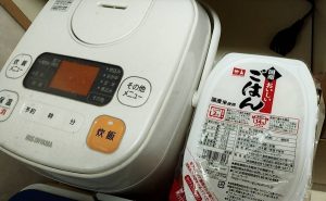 小型炊飯器と180ｇのパックご飯の写真です。