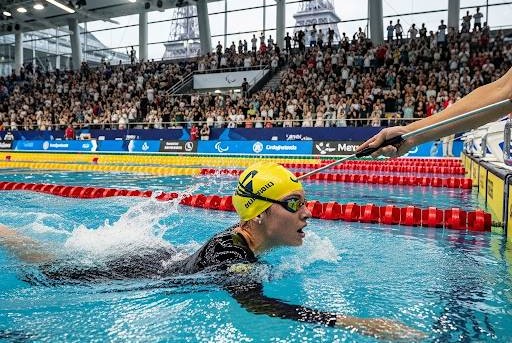水泳パラリンピック競技で、視覚障害者の選手がゴールをする画像です。