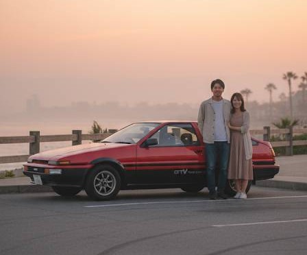 伝説の名車、トヨタ86スプリンタートレノ、海岸駐車場で若者カップルが記念撮影の写真。