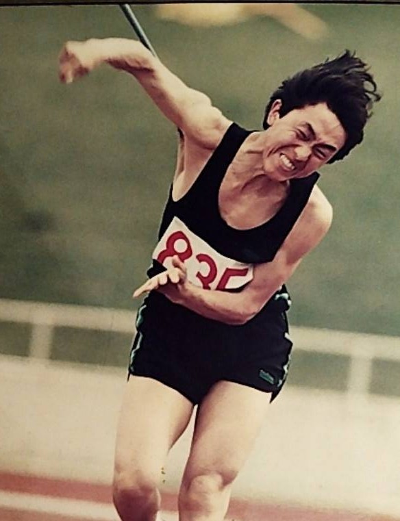 千葉県の陸上競技で、学生のやり投競技が行なわれ、男性の選手がやりを投げた瞬間の画像です。