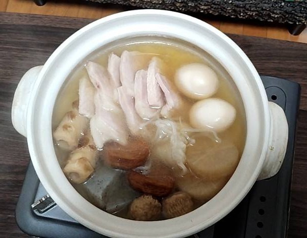 イオンで購入したおでんセット(2名分)と、お歳暮で頂いた高級ハムを土鍋でおでんつゆで温めて出来上がった簡易おでん料理の画像です。