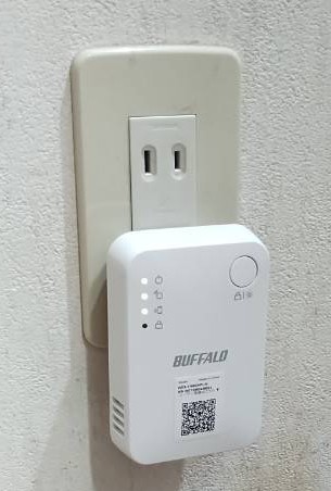 廊下の壁のコンセントに直付けして取り付けた、Wi－Fi小型中継器の画像です。