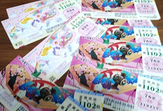 テーブルの上に、宝くじが無造作に重ねて置かれている画像です。