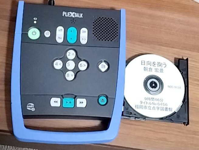 写真の左側が視覚障害者専用の書籍読み上げデイジー図書機械。トレーに乗っているCDは朝倉宏影-日向を掬うの作品です。