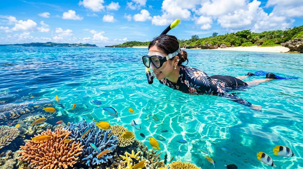 沖縄の海で女性がシュノーケリングをしている画像です。