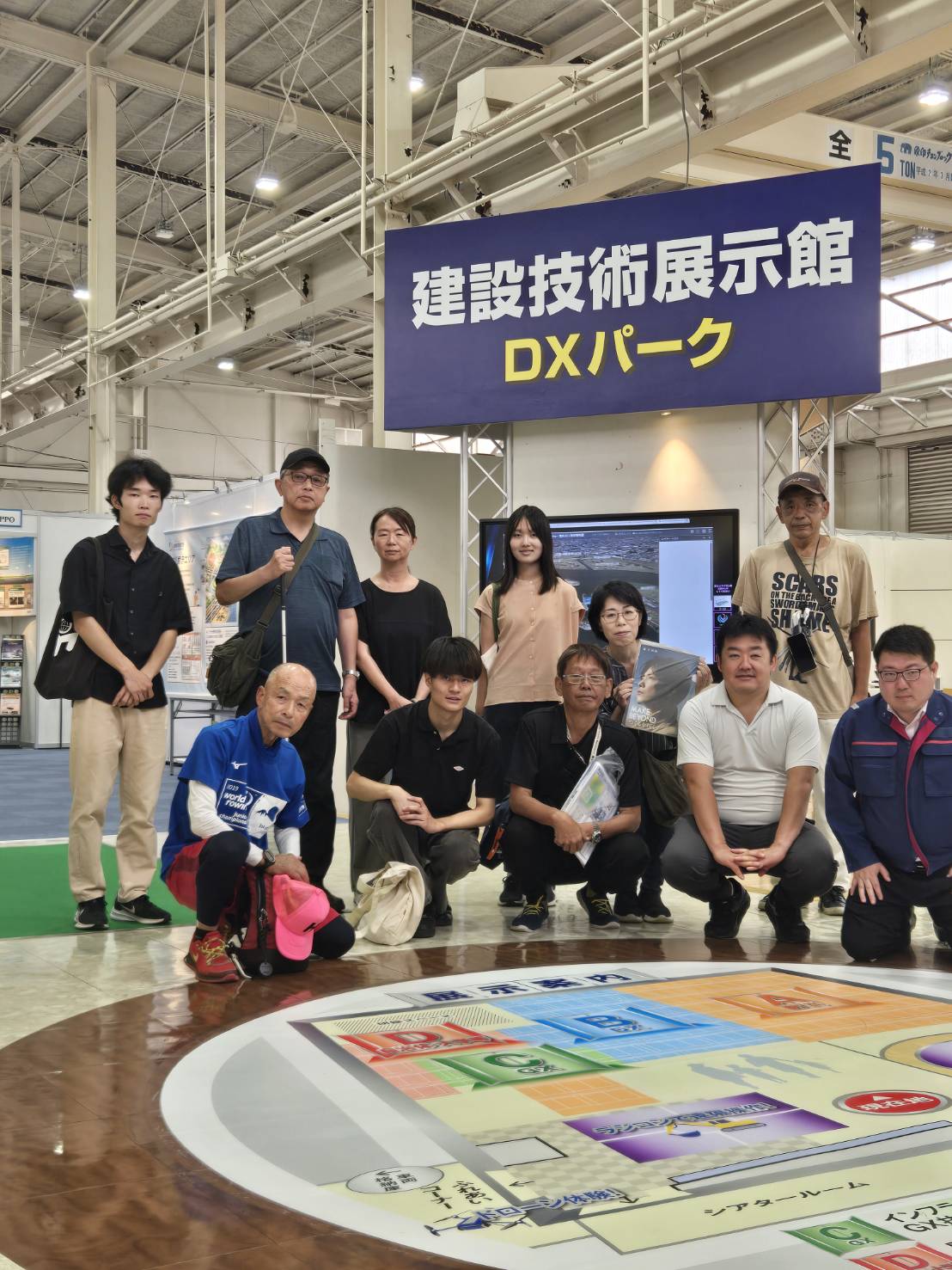 防災の日、国土交通省の建設技術展示館へ体験見学会に参加した際の、関根ジロー千葉県県会議員、峯尾聡太松戸市市会議員選挙立候補者、福祉支援団体アイズルーム石原幸一、その他参加者の記念集合写真です。