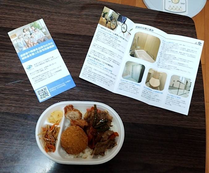 アイズルームの住宅改修三つ折りパンフレットと、ほっともっと「焼肉ランチ弁当」(税込550円)の画像です。