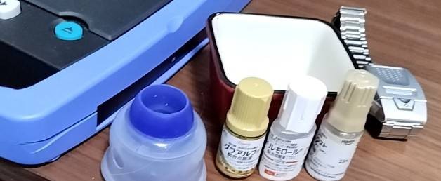 写真左側フレックストーク、写真中に緑内障点眼薬3本、写真中央下、目薬ガイド、写真右、セイコー音声腕時計などが写っている写真です。